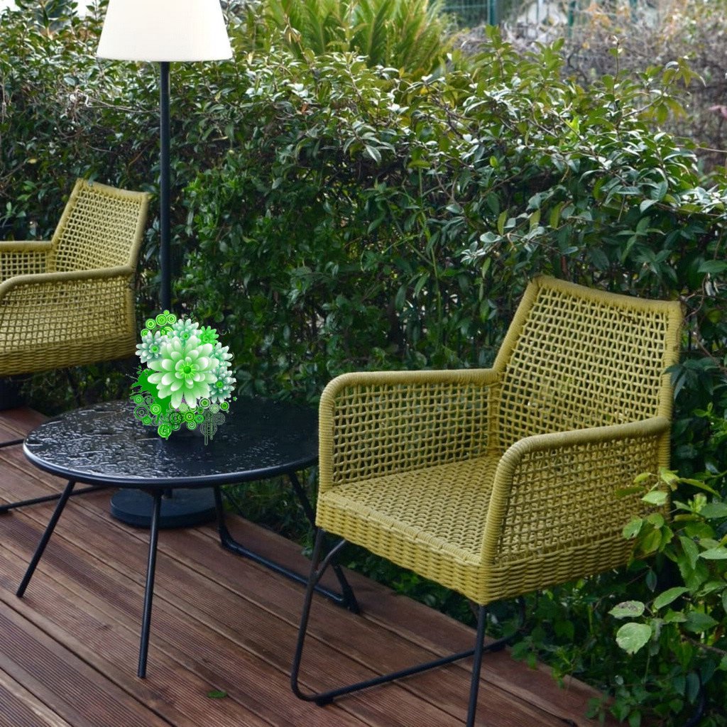 Two green PE rattan chairs placed on a small patio after rainfall, with a damp deck and nearby plants