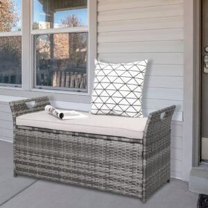 Grey gradient rattan storage ottoman placed under a covered porch outside the home