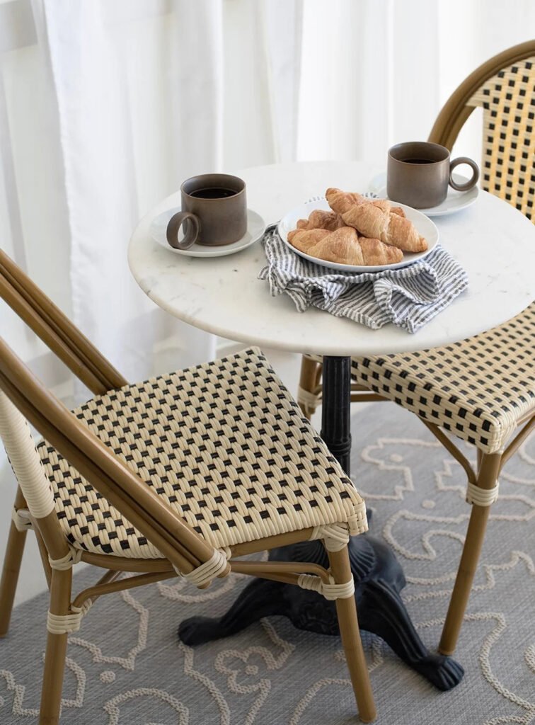 Space-saving rattan bistro set on a narrow balcony with chairs tucked in