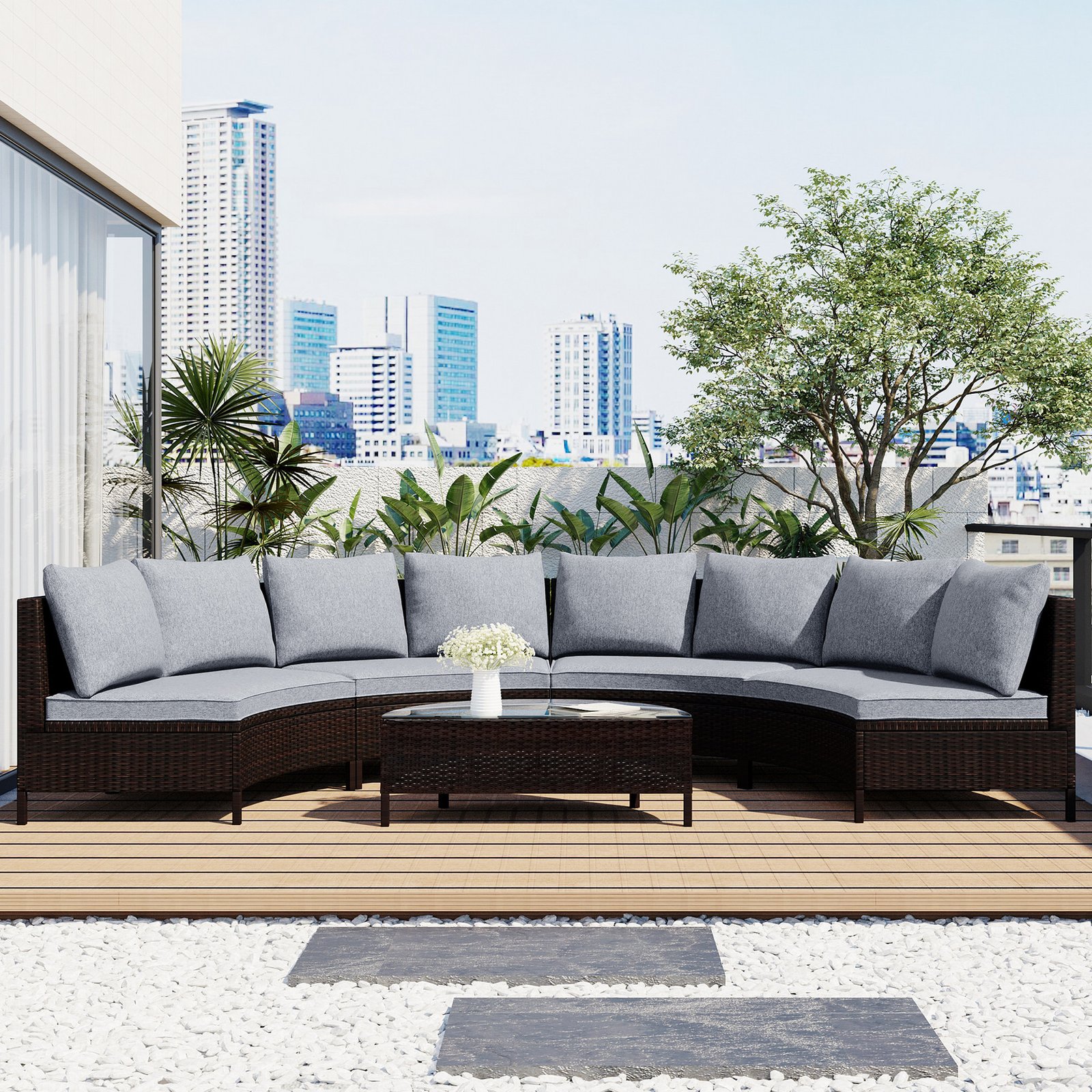 5-piece brown rattan half-moon sectional set arranged on city rooftop terrace with plants and magazines, skyscrapers in the background