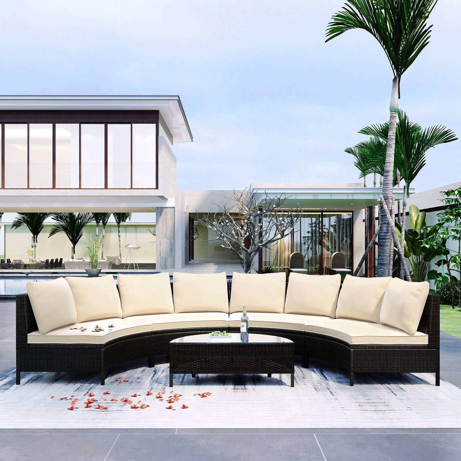 5-piece brown rattan half-moon sectional set with beige cushions in courtyard near palm trees with water and fruit on tempered glass table