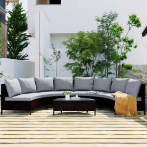 5-piece brown rattan half-moon sectional set styled on outdoor deck with green trees, magazines on table, and blanket on sofa