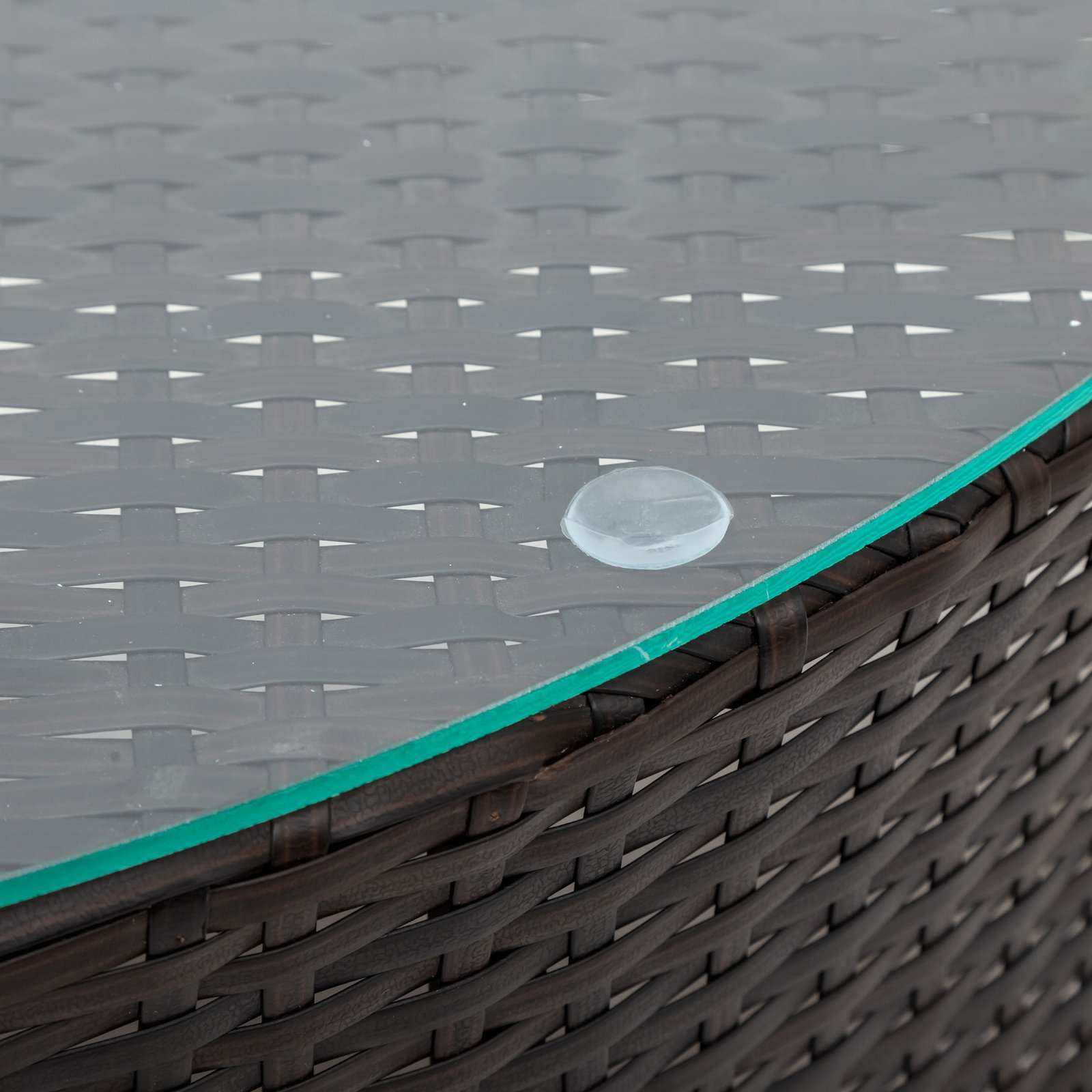 Close-up of wicker and tempered glass tabletop detail on 5-piece brown rattan half-moon sectional set