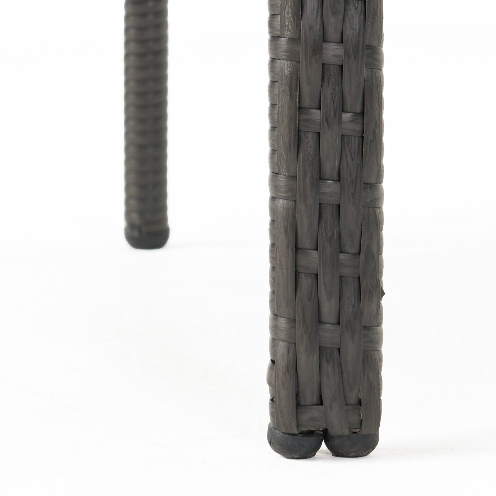 Close-up of gray rattan patio dining set legs with protective foot pads