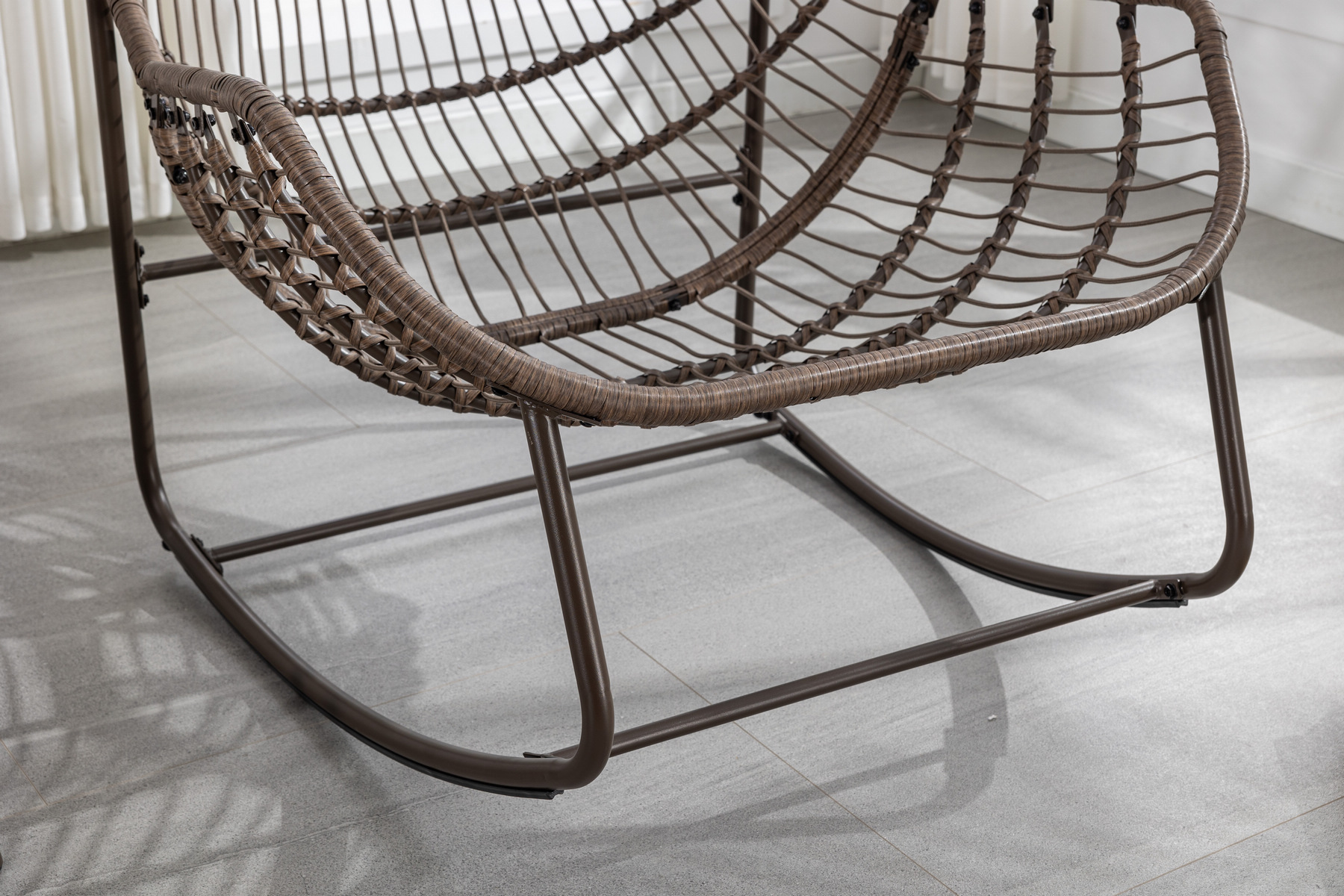 outdoor rattan rocking chair frame detail without cushion showing wicker weave and protective foot pads