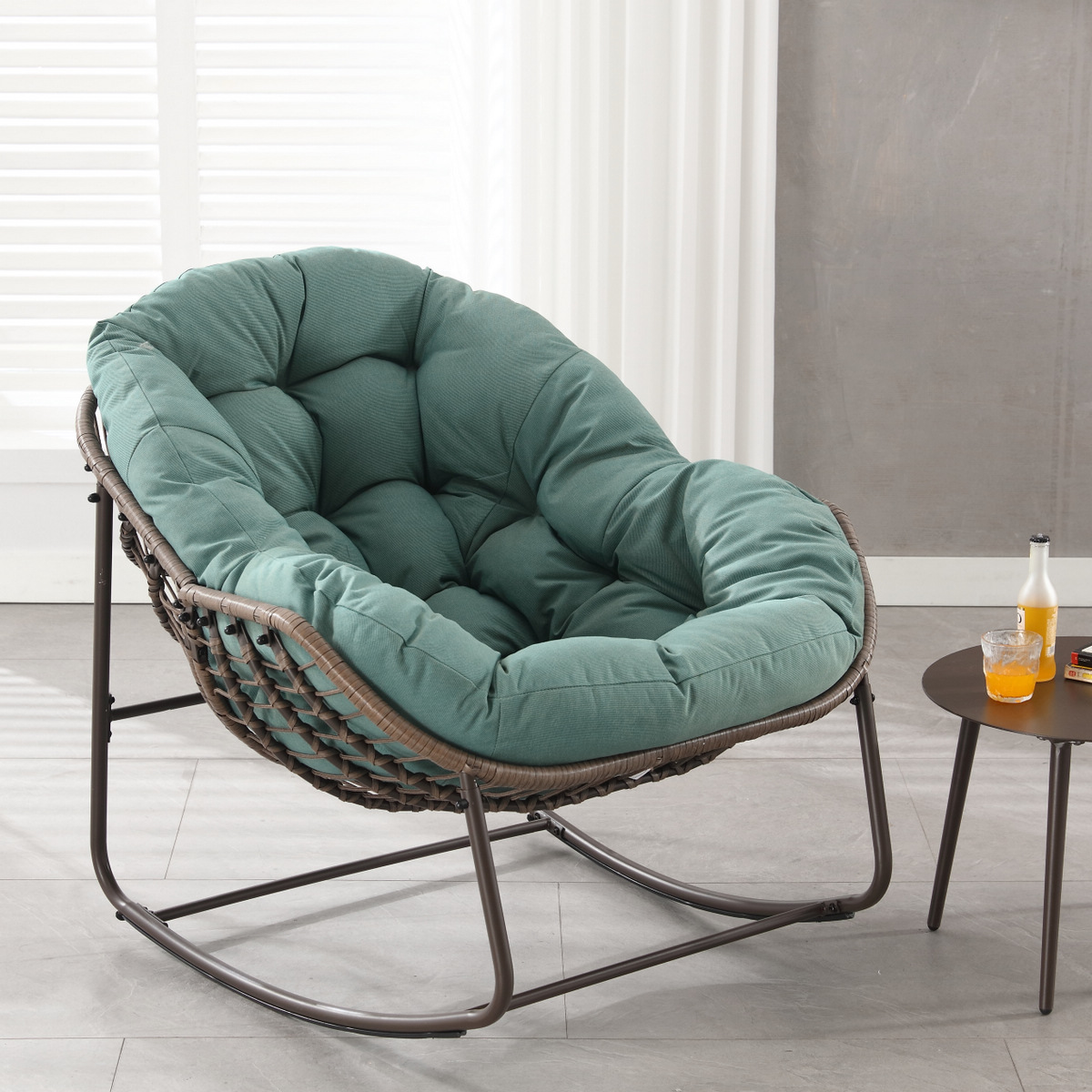 oversized outdoor rattan rocking chair with green cushion and brown wicker frame