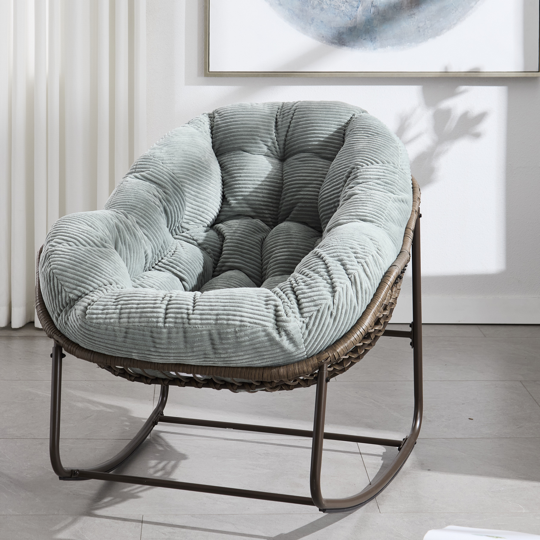 oversized outdoor rattan rocking chair with light green cushion and brown wicker frame