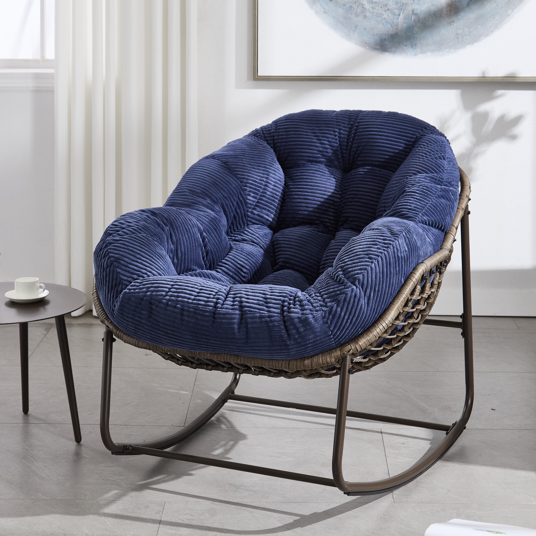 oversized outdoor rattan rocking chair with navy blue cushion and brown wicker frame