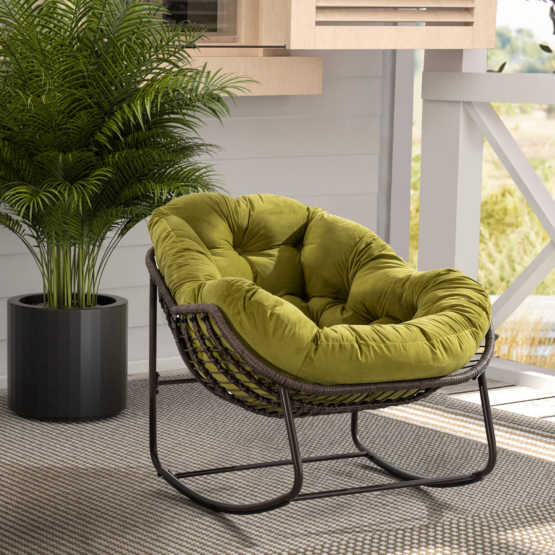 oversized outdoor rattan rocking chair with olive green cushion and brown wicker frame