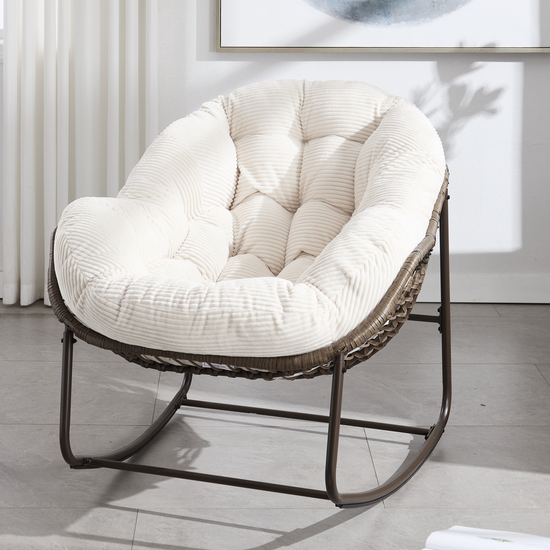 oyersized outdoor rattan rocking chair with white cushion and brown wicker frame