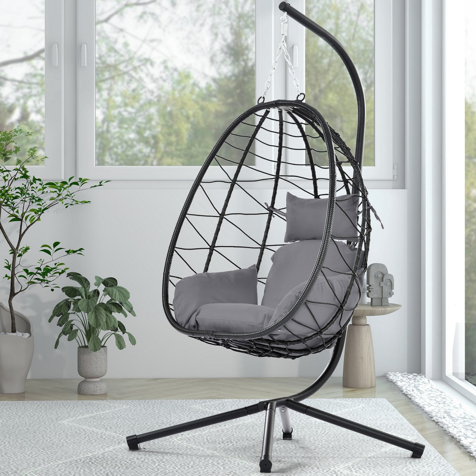 Single person cream PE rattan hanging egg chair with a plush Dark Gray cushion on a sunny farmhouse patio.