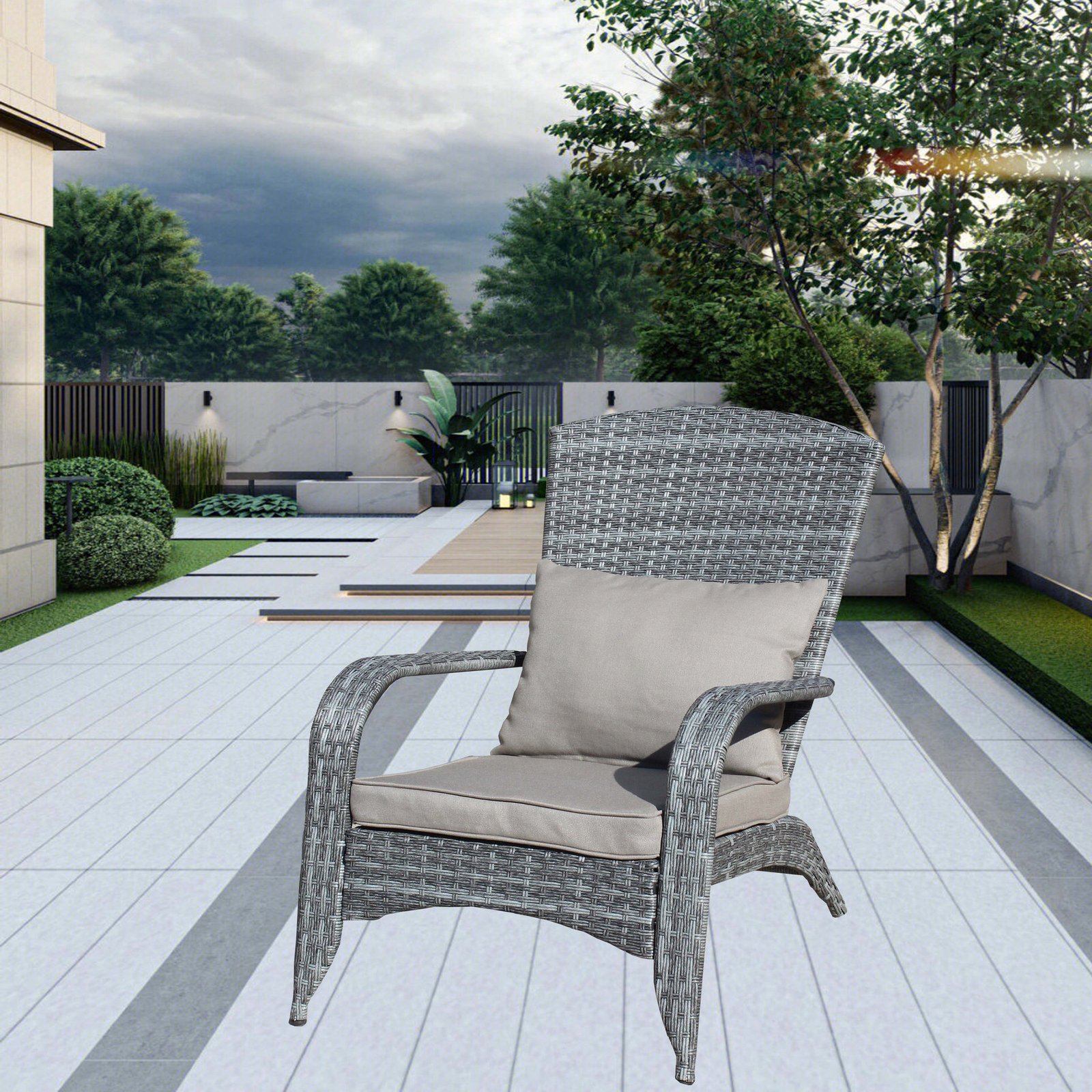 A lifestyle scenic view of the gray wicker patio single chair with matching gray cushions set in a lush green backyard garden layout.