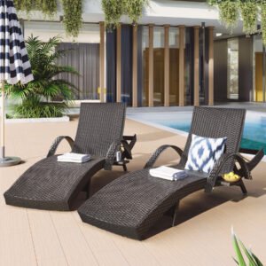 Front view of two dark brown wicker chaise lounge recliners with extended pull-out side tables next to a sunny backyard swimming pool.