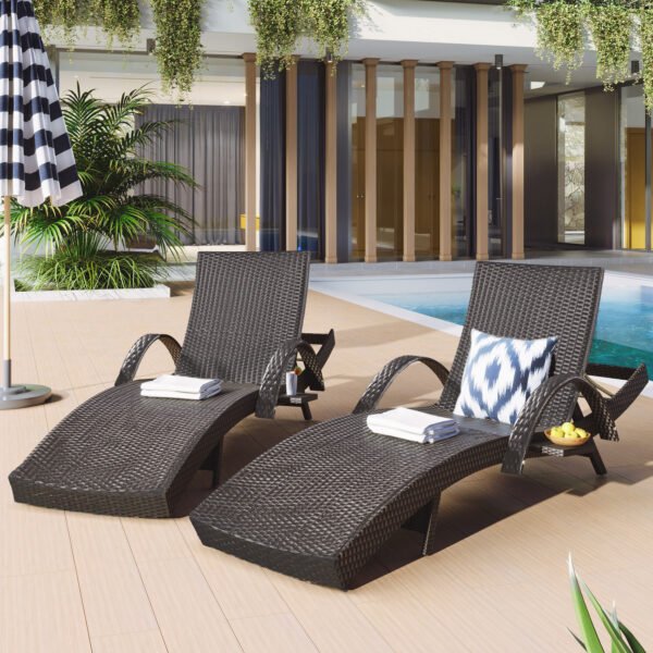 Front view of two dark brown wicker chaise lounge recliners with extended pull-out side tables next to a sunny backyard swimming pool.
