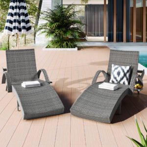 Front view of two gray wicker chaise lounge recliners with extended pull-out side tables next to a sunny backyard swimming pool.