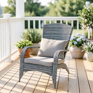 Front view of a gray wicker patio accent chair with plush gray seat and back cushions on a sunny front porch.