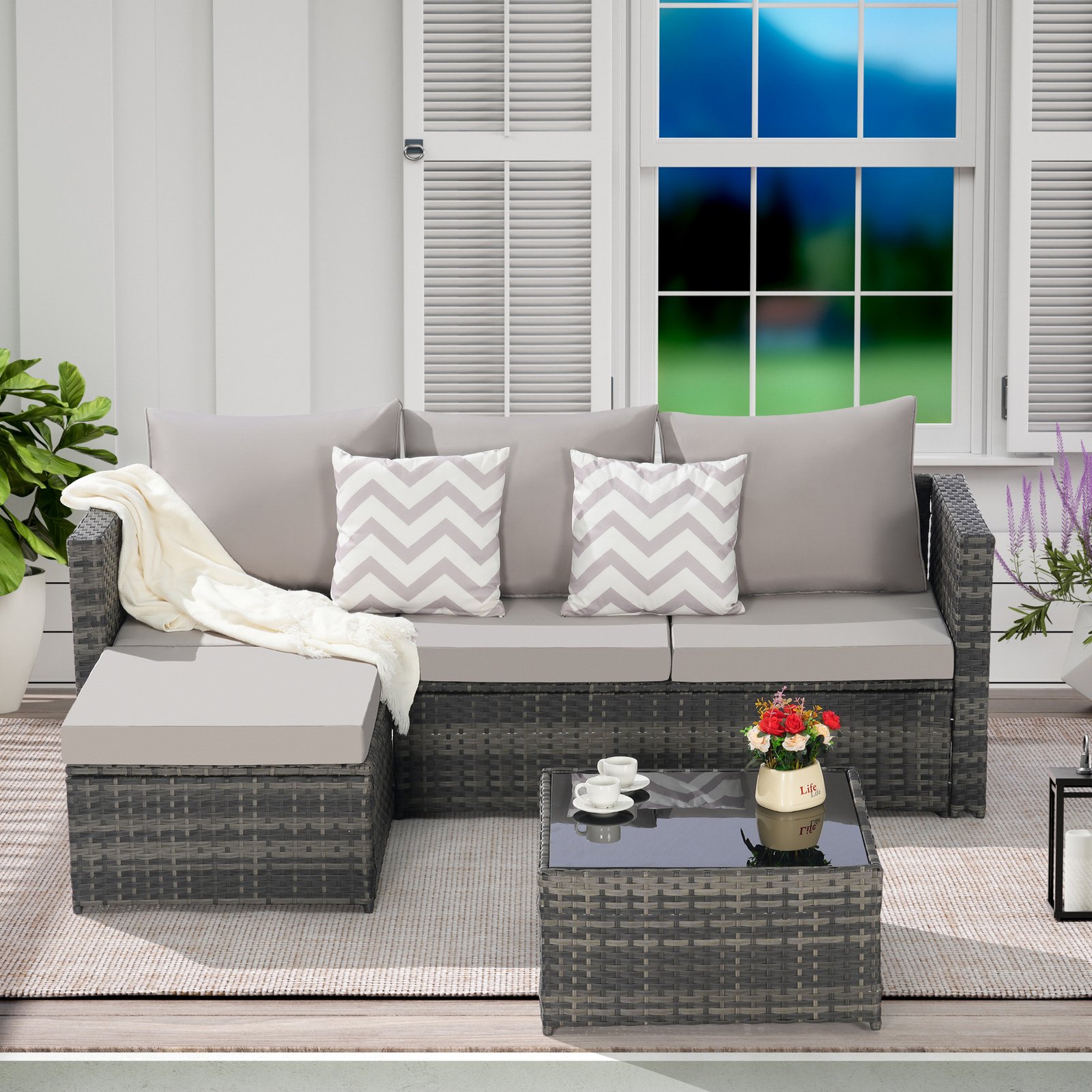 2-Piece L-shaped wicker patio furniture set with light gray cushions, attached ottoman and detachable coffee table displayed on an outdoor terrace