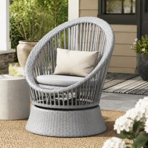 Modern swivel wicker lounge chair with cushion in silver grey finish placed on a residential patio, featuring a round PE rattan design and comfortable lounge seating