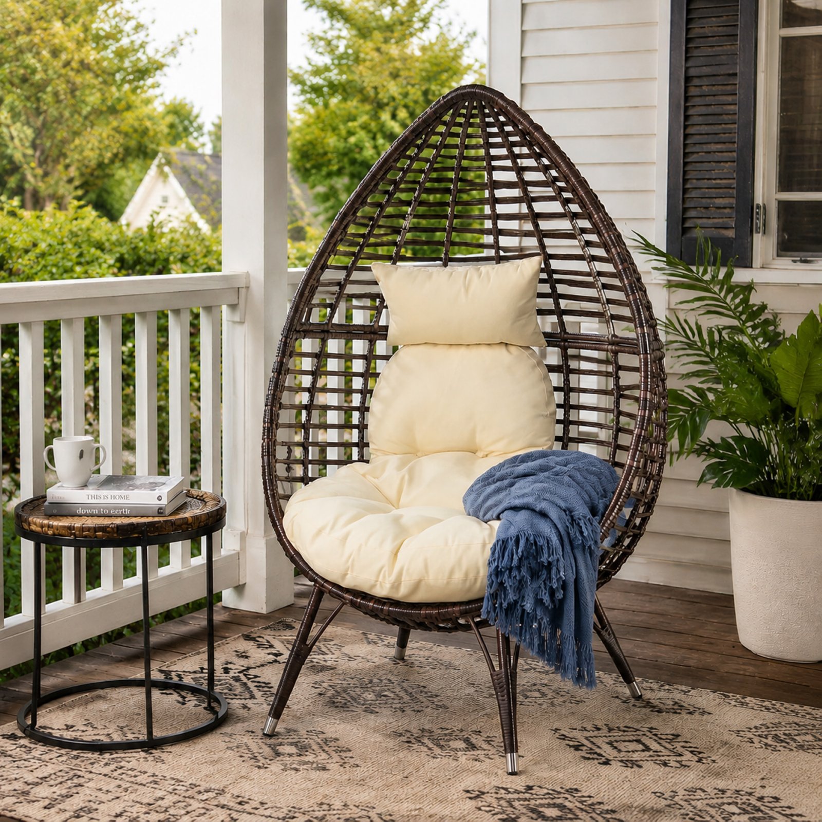 Teardrop lounge chair with cushion placed in a cozy outdoor porch of a modern American home, styled with side table and natural daylight.