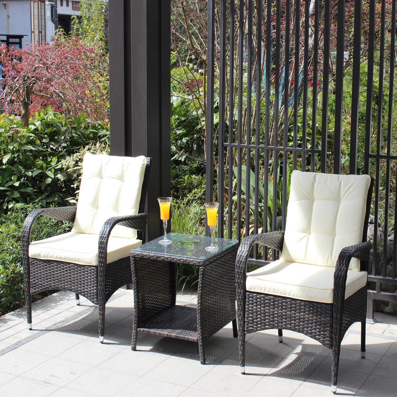 3 piece outdoor wicker conversation set with cushions and tempered glass coffee table on covered patio with drinks