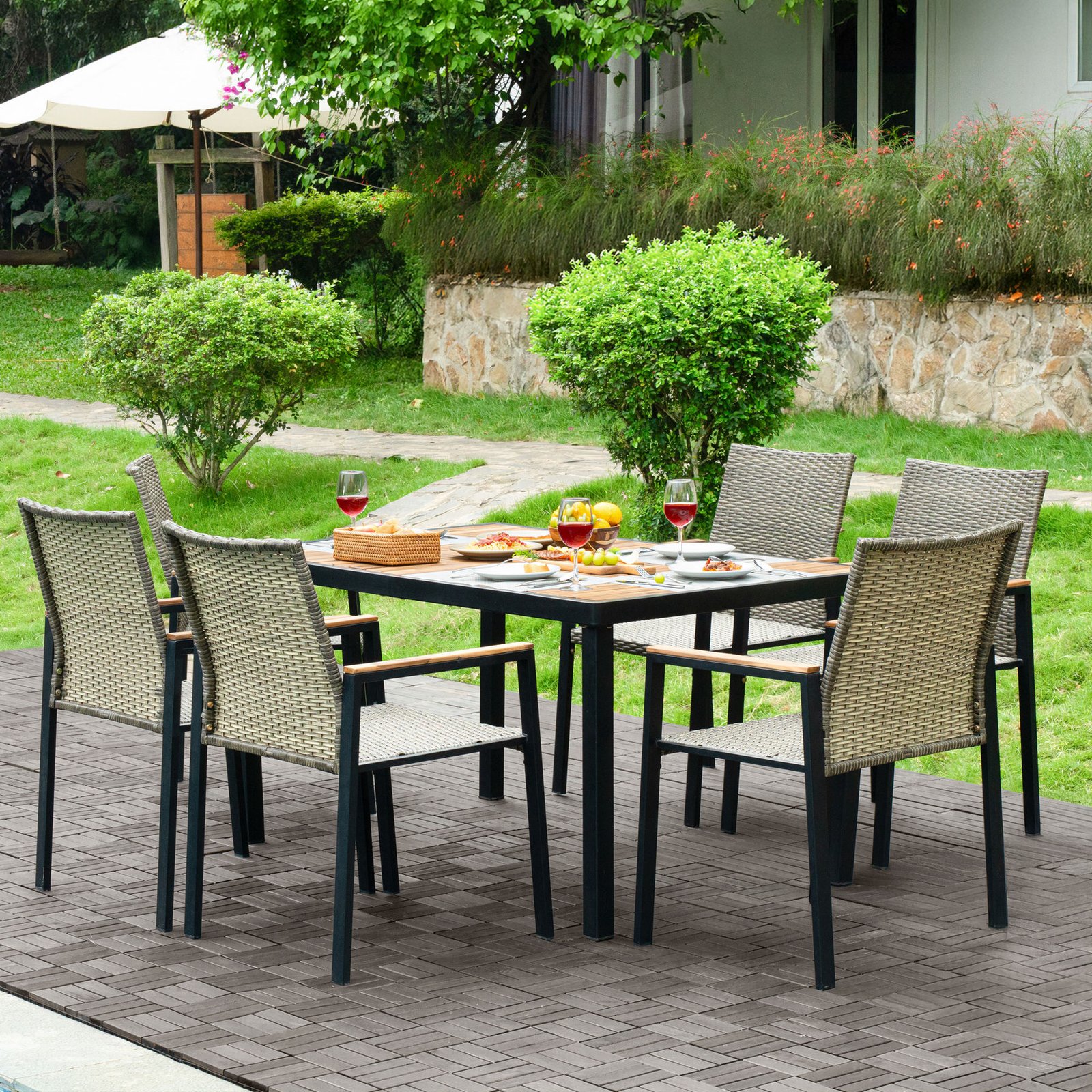 7-piece outdoor wicker dining set with acacia wood tabletop arranged on a patio for outdoor dining and entertaining