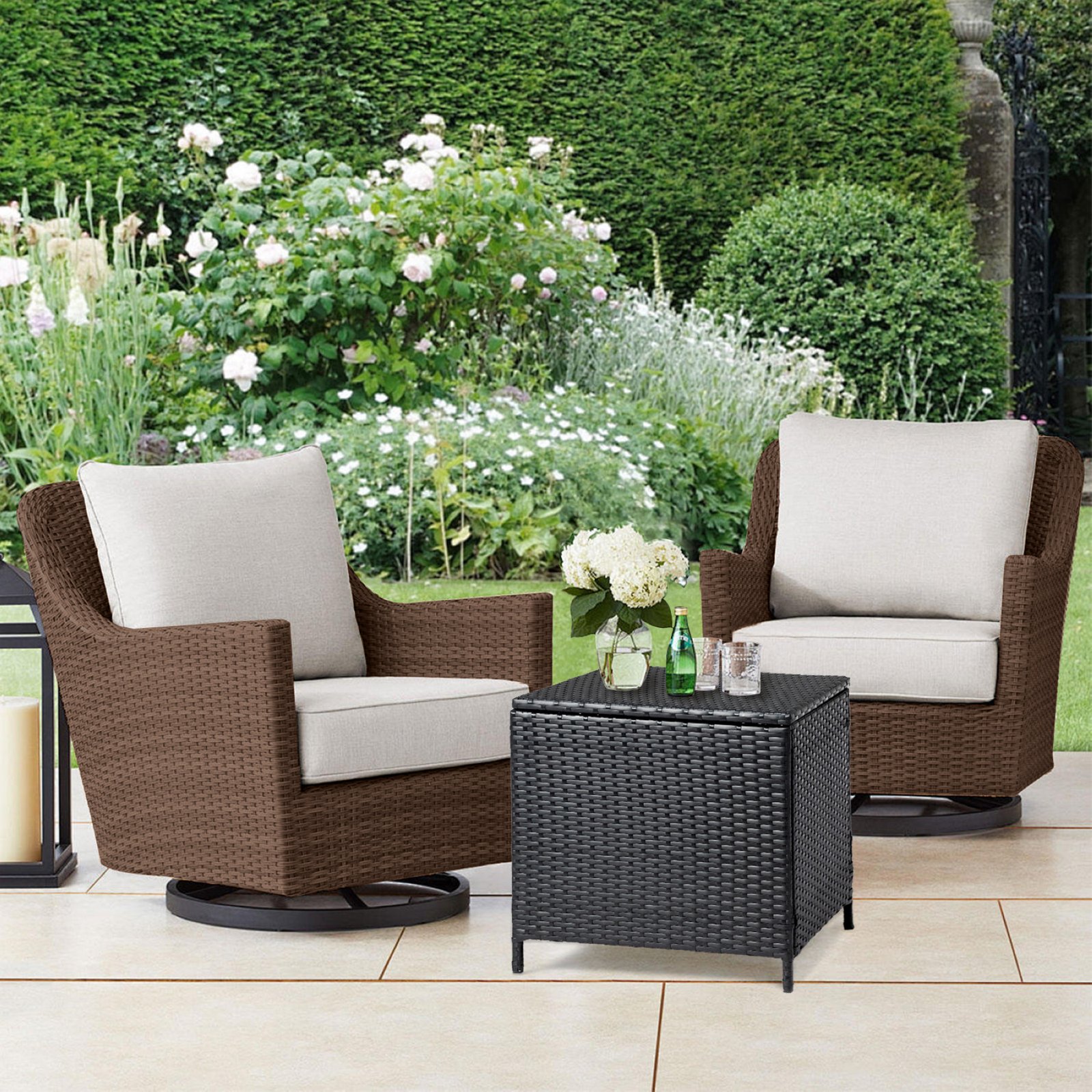 Black outdoor wicker storage side table with drinks beside a rattan chair on patio