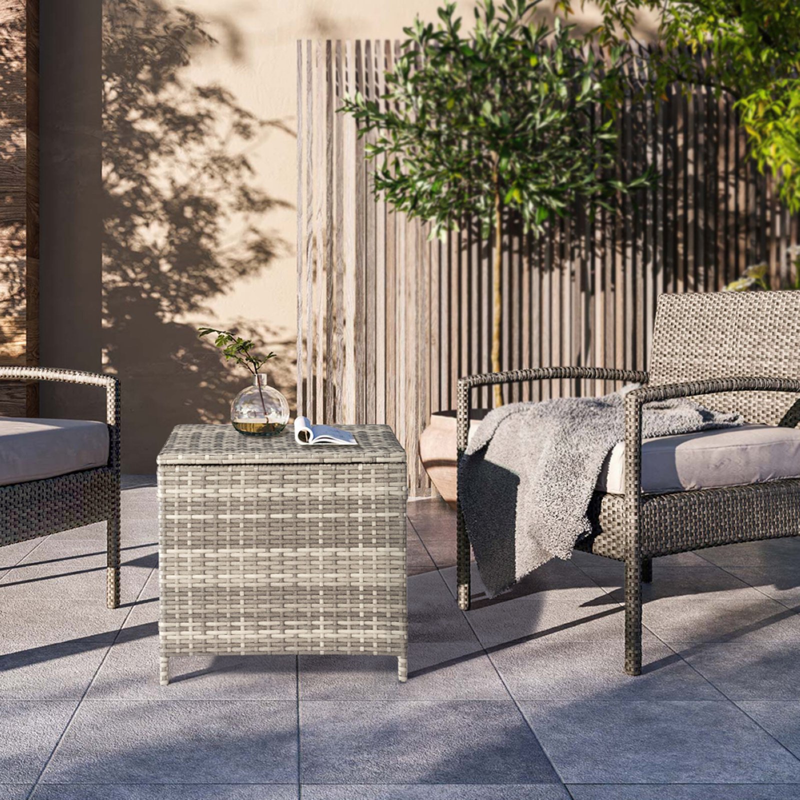 Gray outdoor wicker storage side table paired with rattan chair in patio setting