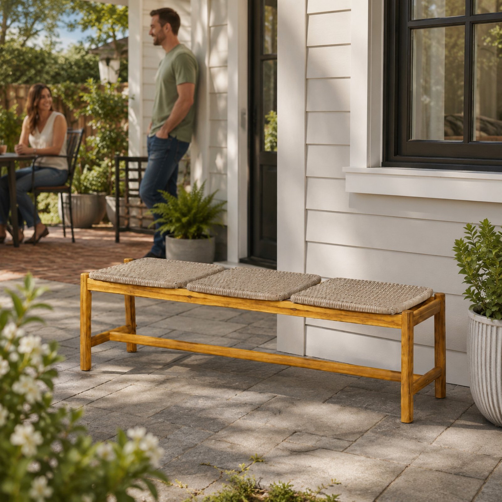 Outdoor acacia wood bench with rattan accents placed on a residential patio with a relaxing outdoor lifestyle setting