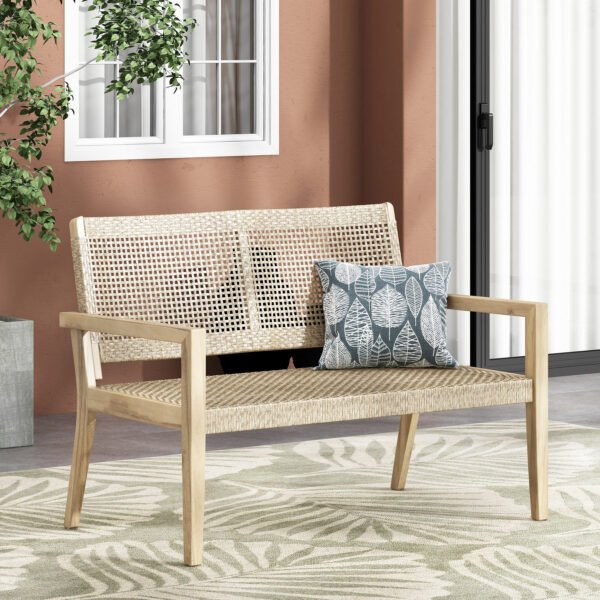 Outdoor acacia wood loveseat with wicker seating and cushions on a porch patio by the home
