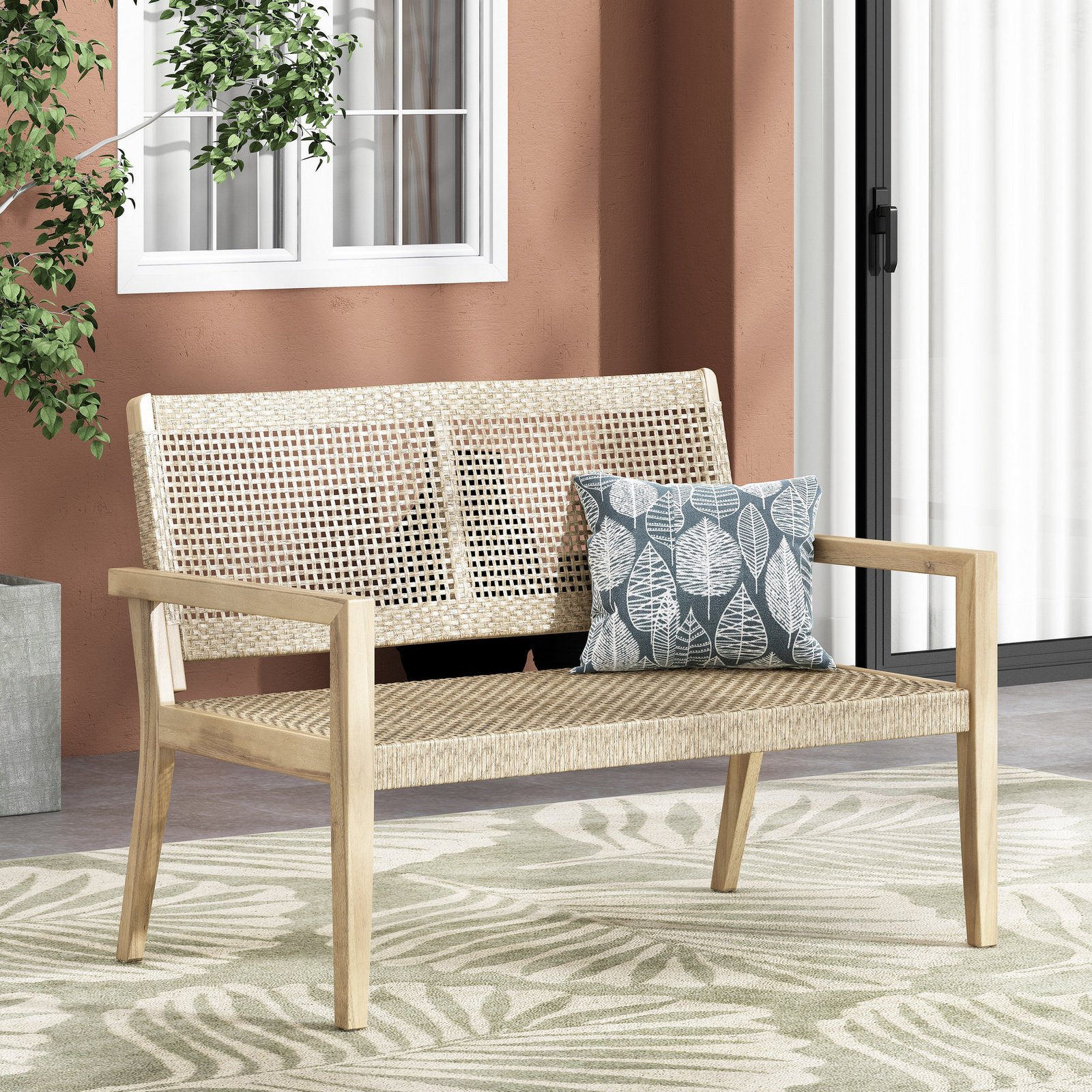 Outdoor acacia wood loveseat with wicker seating and cushions on a porch patio by the home