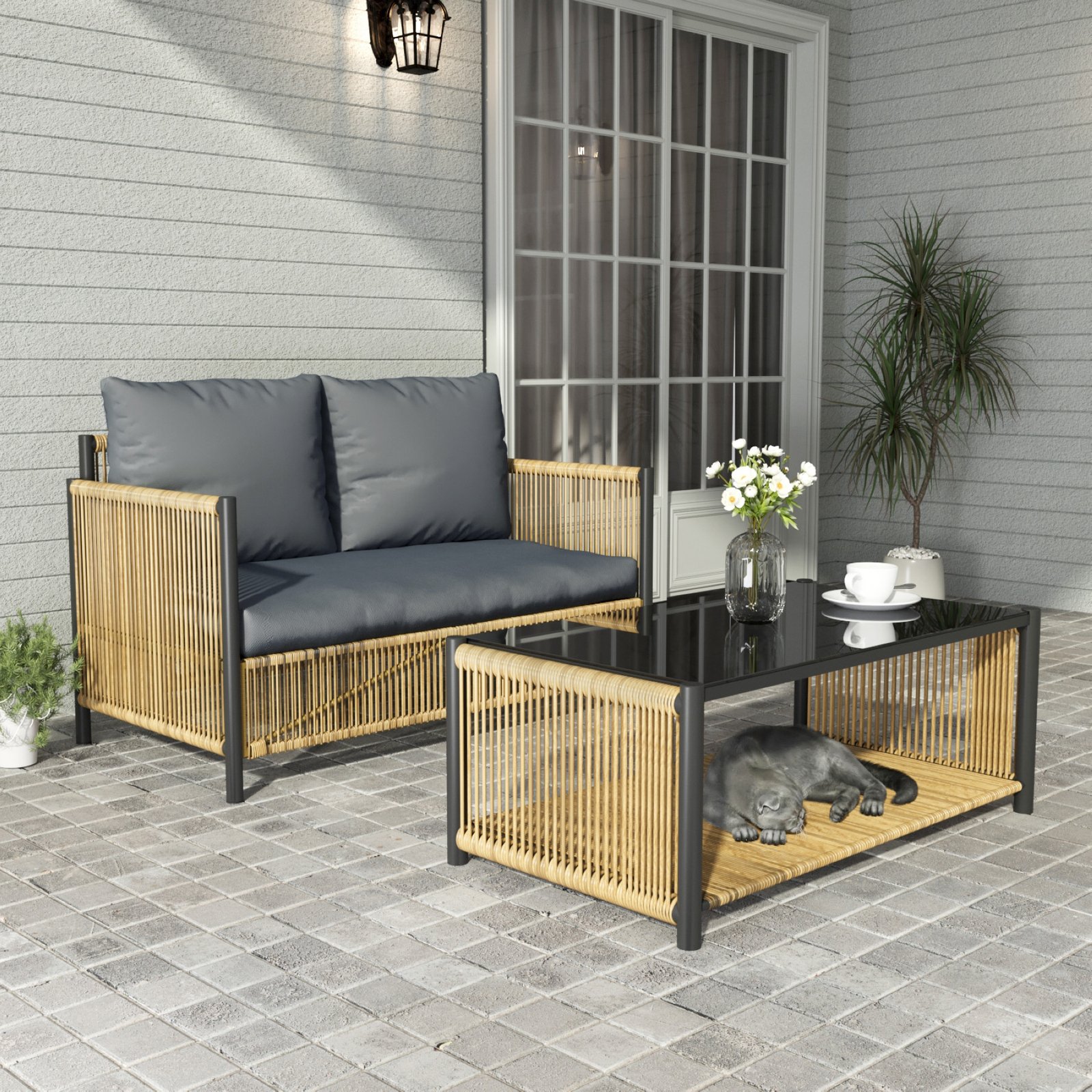 Outdoor wicker loveseat sofa set with coffee table on a covered patio with flowers and pet