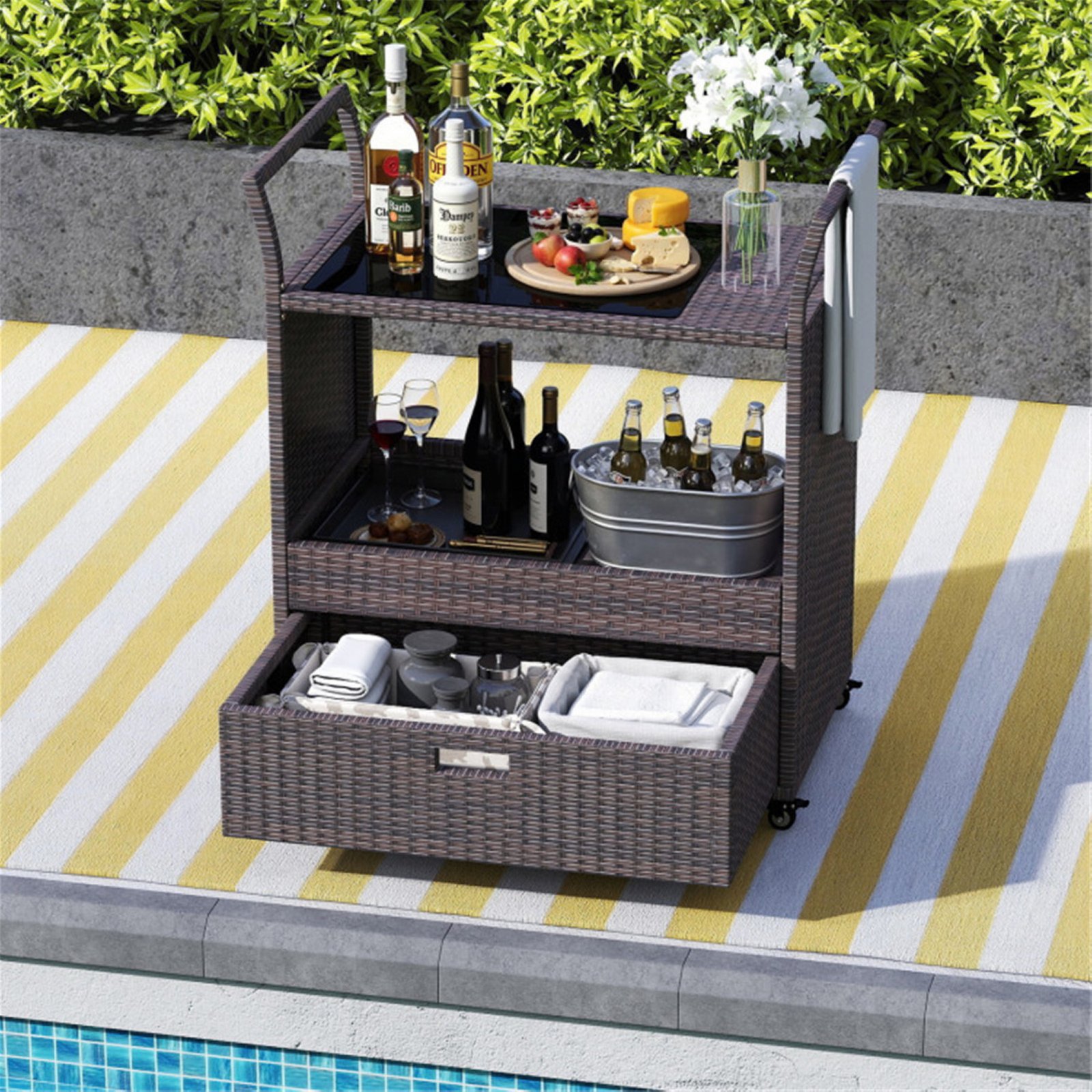 Rattan outdoor bar cart with open drawer serving drinks and patio essentials in a backyard setting