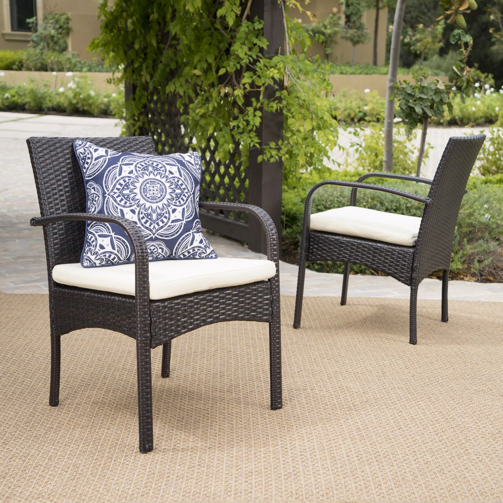 Set of 2 brown PE wicker outdoor dining chairs with cushions placed in a backyard patio setting for garden, deck, and balcony seating