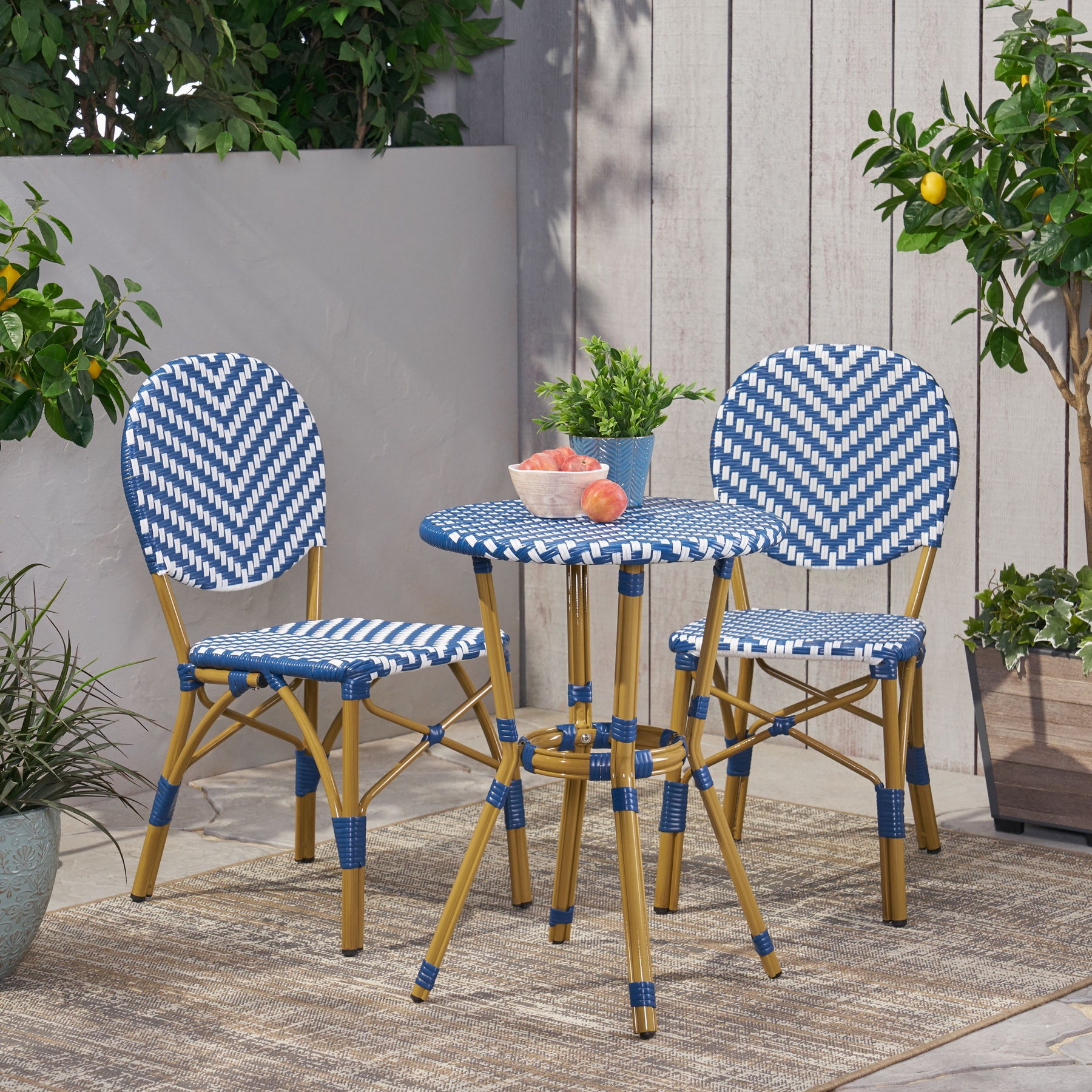 3 piece outdoor French bistro set with navy blue and white PE rattan chairs and round table on a patio